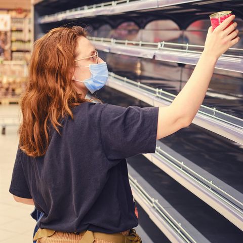 Eine junge Frau vor einem leeren Supermarktregal