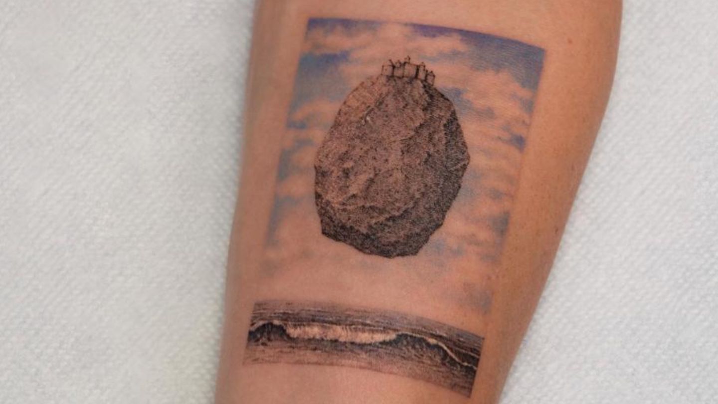Ein Schloss auf einem schwebenden Stein. "Das Schloss in den Pyrenäen" von Maler René Magritte als Tattoo