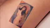 Ein Tattoo von einer nackten Frau auf dem Bauch eines Mannes