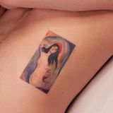 Ein Tattoo von einer nackten Frau auf dem Bauch eines Mannes