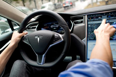 Ein Mann sitzt am Steuer eines Tesla Model S.