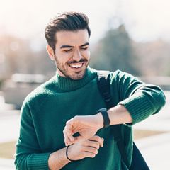 Deals des Tages: Junger Mann schaut auf seine Smartwatch