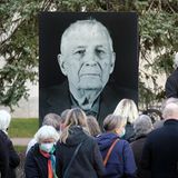 Teilnehmer einer Gedenkstunde für den Buchenwald-Überlebenden Boris Romantschenko stehen vor dessen Foto