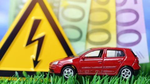 Ein Miniaturauto mit Geldscheinen im Hintergrund