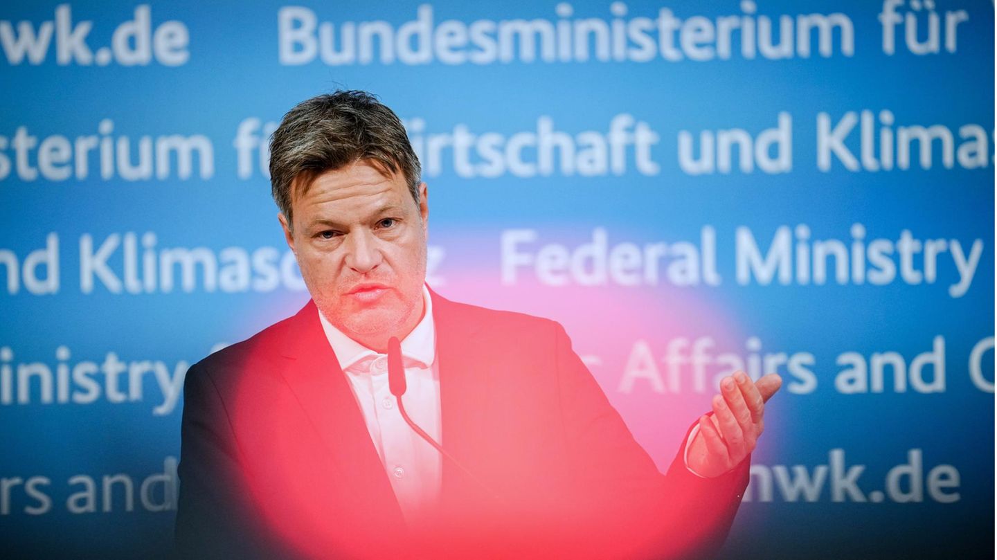 Ein weißer Mann in Anzug steht vor einer blauen Wand mit Schriftzügen "Bundesministerium für Wirtschaft und Klimaschutz"