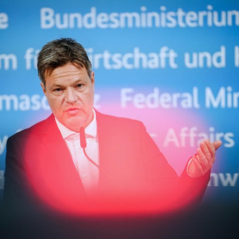 Ein weißer Mann in Anzug steht vor einer blauen Wand mit Schriftzügen "Bundesministerium für Wirtschaft und Klimaschutz"