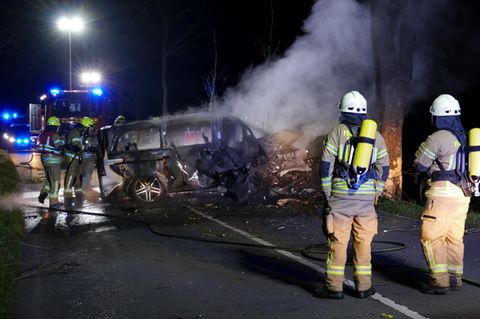 Siegburg: Feuerwehrmänner stehen vor einem ausgebrannten Lieferwagen