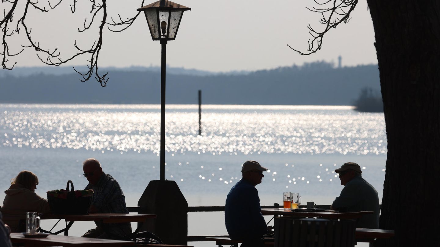 Ausflüger sitzen in der Sonne in einem Lokal am Ammersee