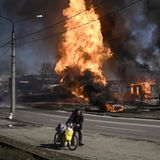 Mann flieht mit Fahrrad und gepackten Taschen aus Charkiw