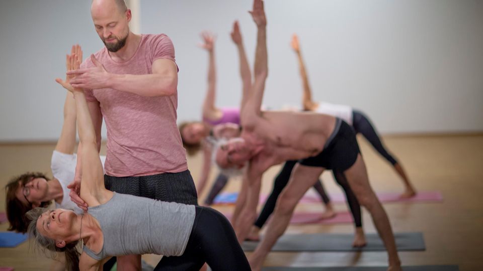 yoga teacher Dr. Ronald Steiner helps a yoga student