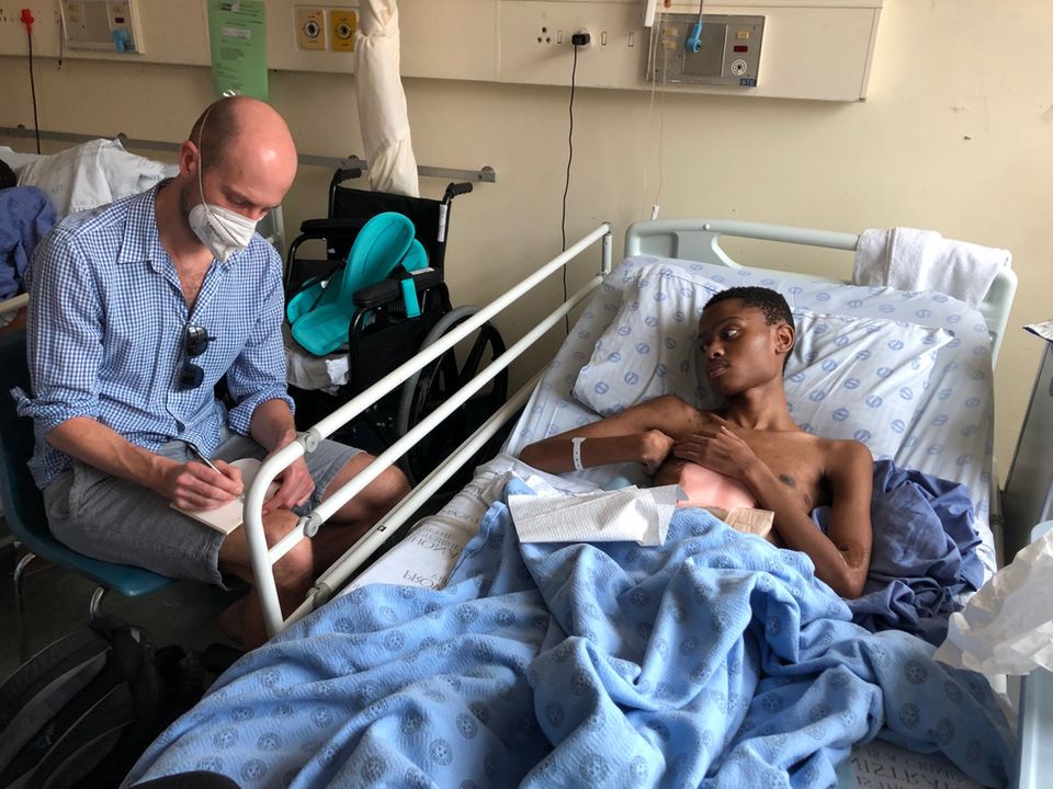 Der 19-Jährige Ongama Mpuhly (rechts) mit Marc Goergen von der Stiftung stern im Tygerberg-Krankenhaus bei Kapstadt. Mpuhly überlebte einen Mordanschlag nur knapp