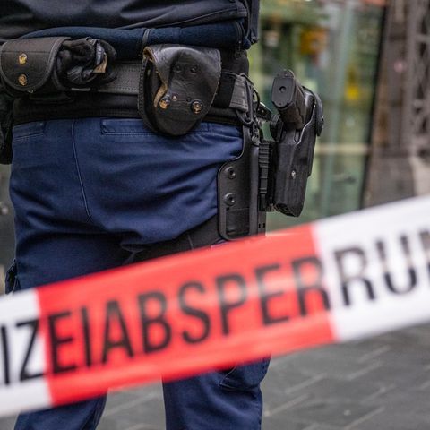 Ein Polizist steht hinter einer Polizeibasperrung