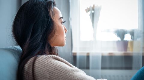 Mental erschöpfte Frau sitzt auf der Couch
