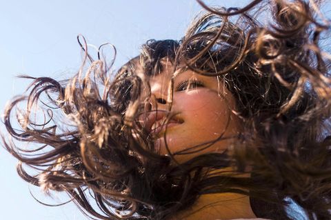 Cora hüpft auf einem Trampolin. Ihre braunen Haare fliegen nach oben