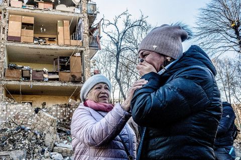 Zwei Frauen trauern vor einem bombardierten Haus in Kiew