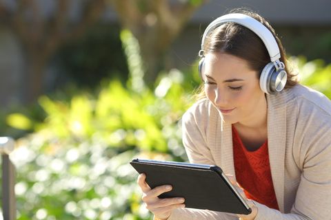 Frau hat ein Tablet in der Hand und es strahlt blaues Licht aus