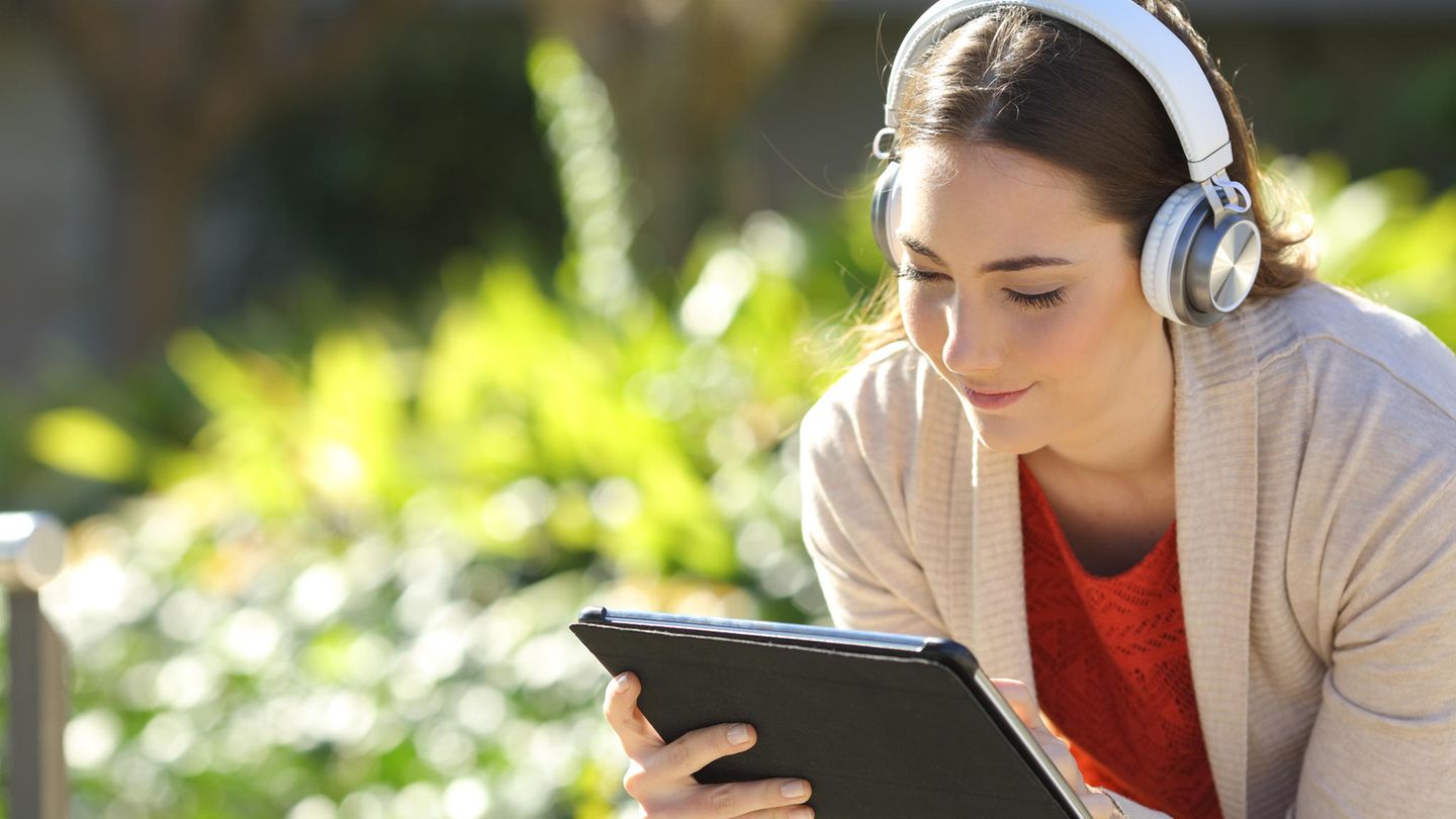 Frau hat ein Tablet in der Hand und es strahlt blaues Licht aus