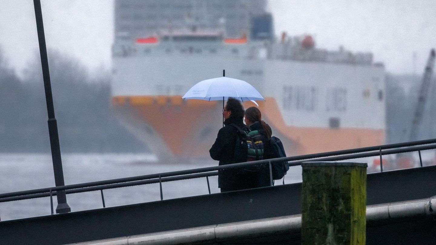 Schmuddel-Wetter Hamburg: Ein Paar steht mit Schirm an einem Fähranleger