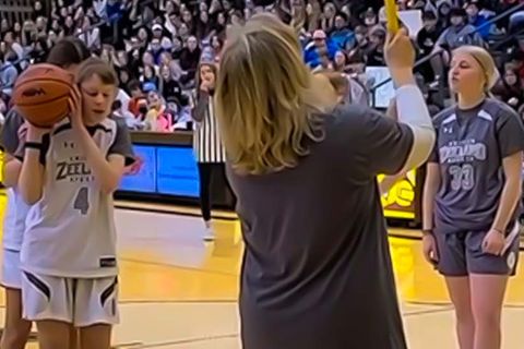 Blinde Spielerin versucht beim Basketball Spiel einen Korb zu werfen