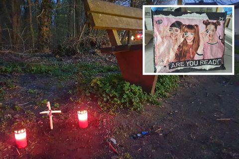 Fundort einer Babyleiche in Mönchengladbach: Kerzen und ein Holzkreuz neben einer Parkpank