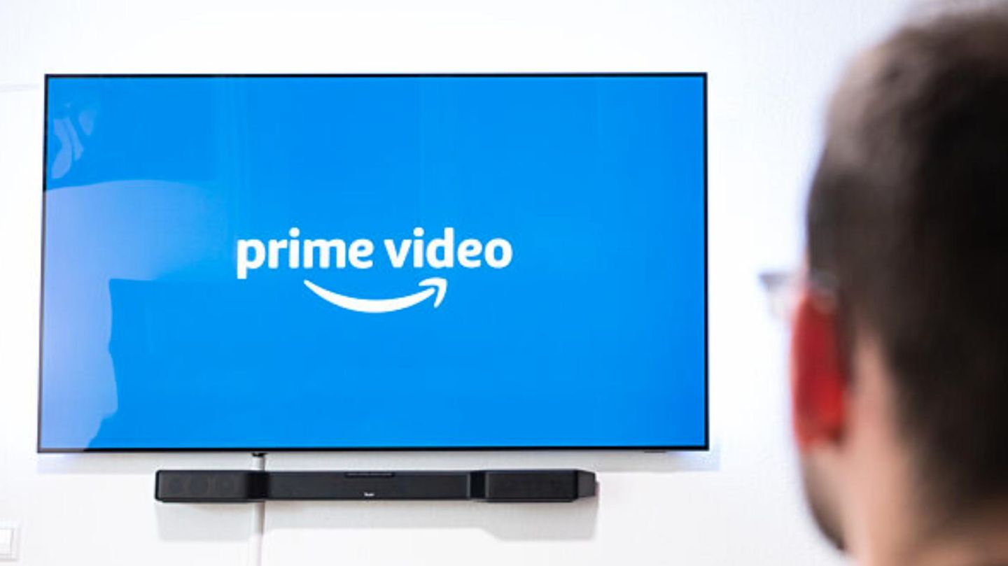 Ein Mann schaut auf einen Fernseher mit Prime-Video-Logo