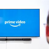 Ein Mann schaut auf einen Fernseher mit Prime-Video-Logo