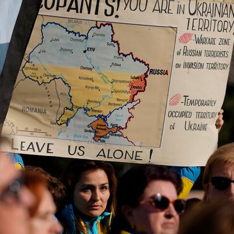 Auf einer Demonstration gegen den Ukraine-Krieg hält ein Demonstrant ein Schild mit der Karte der Ukraine