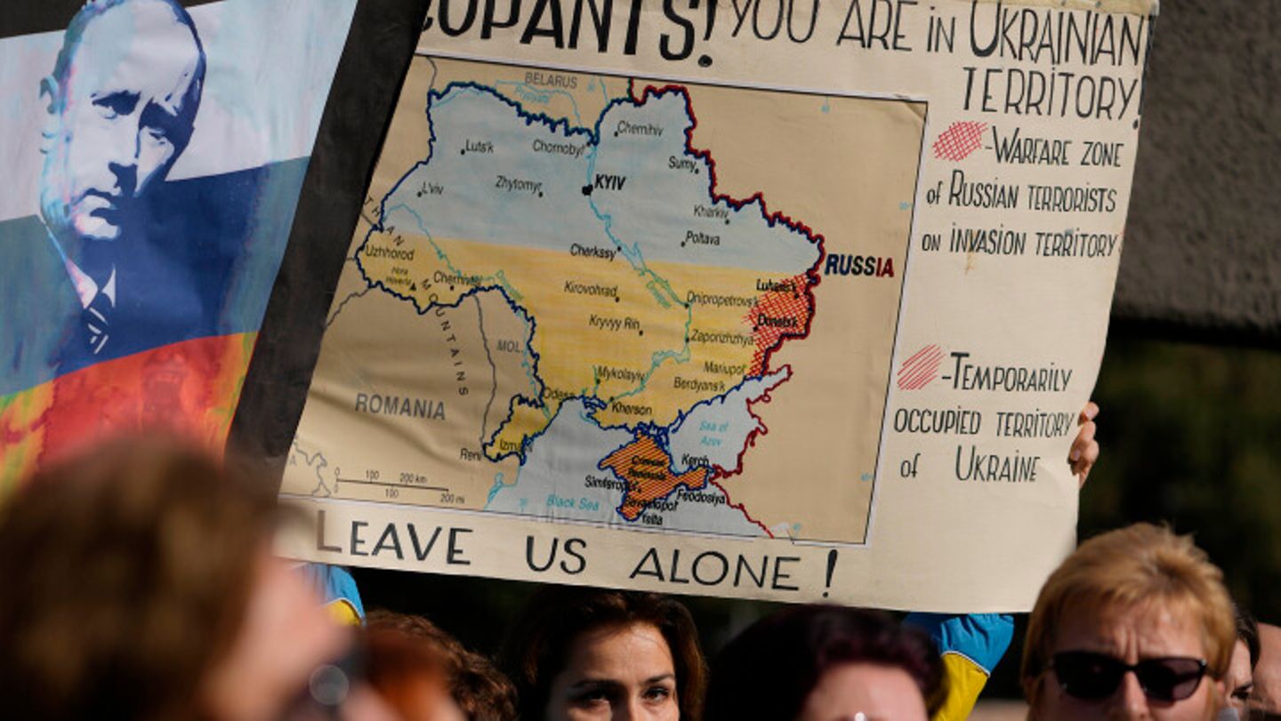Auf einer Demonstration gegen den Ukraine-Krieg hält ein Demonstrant ein Schild mit der Karte der Ukraine
