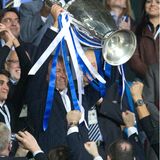 Roman Abramowitsch lacht und streckt im Fußballstadion einen großen Pokal in die Höhe