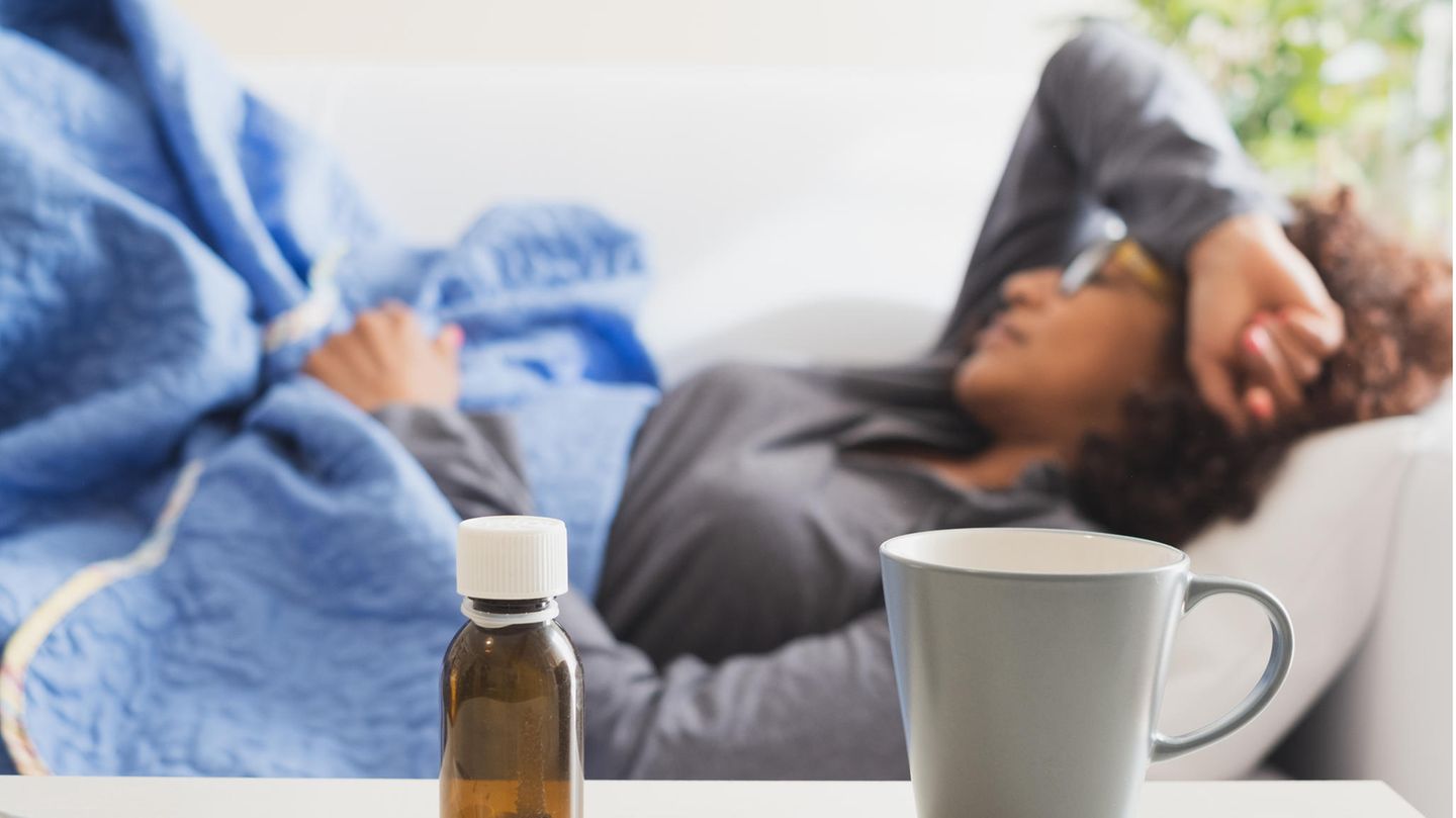 In Quarantäne: Eine Frau liegt krank auf dem Sofa