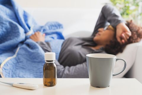 In Quarantäne: Eine Frau liegt krank auf dem Sofa