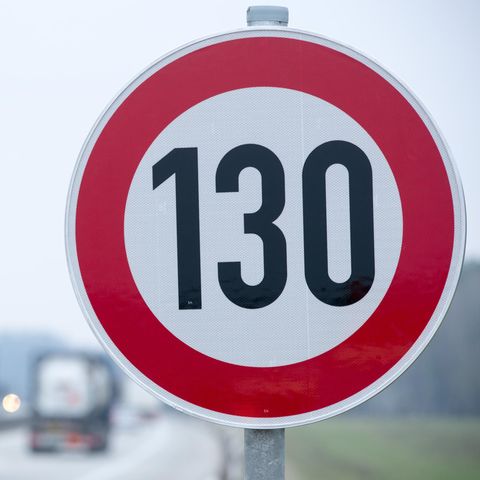 An der Autobahn steht ein Verkehrsschild mit der Geschwindigkeitsangabe von 130 Stundenkilometern