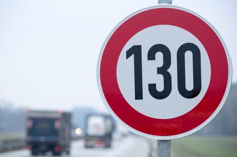 An der Autobahn steht ein Verkehrsschild mit der Geschwindigkeitsangabe von 130 Stundenkilometern