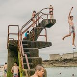 Kinder schwimmen und tauchen im Lido am Strand von Saint-Malo, einer ummauerten Hafenstadt in der Bretagne im Nordwesten Frankreichs am Ärmelkanal.      Ian Teh hat drei Monographien veröffentlicht, "Undercurrents" (2008), "Traces" (2011) und "Confluence" (2014). Seine Arbeiten sind Teil der ständigen Sammlung des Los Angeles County Museum of Art (LACMA), des Museum of Fine Arts, Houston (MFAH) und des Hood Museum in den USA. Ausgewählte Einzelausstellungen umfassen die Jack Shainman Gallery in New York im Jahr 2004, Flowers in London im Jahr 2011 und das Kunsthal Museum in Rotterdam im Jahr 2012.