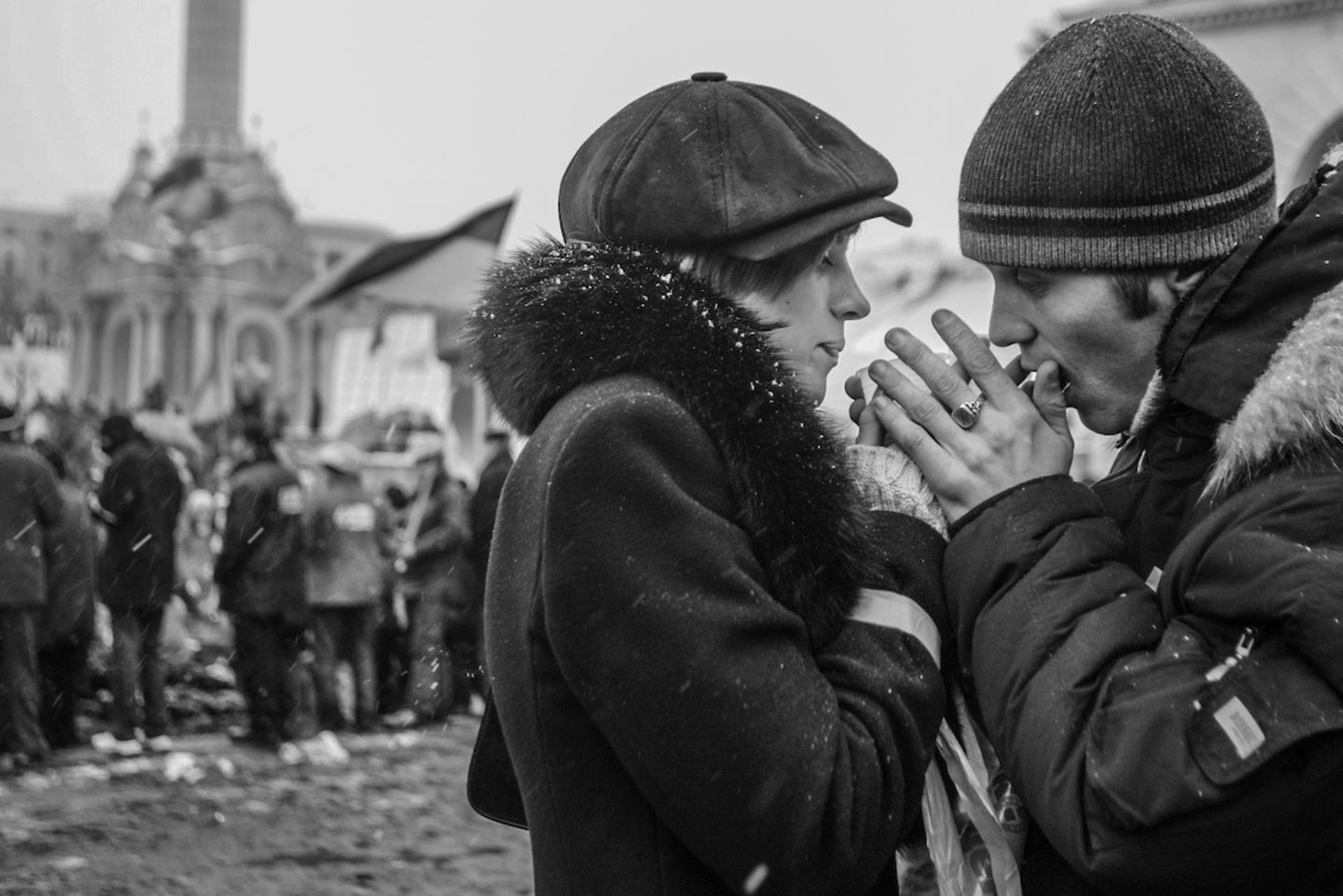 "Ukrainian Demonstrators in the Orange Revolution", David Guttenfelder Ein Paar wärmt sich in der bitteren Kälte gegenseitig die Hände und schließt sich mit anderen ukrainischen Demonstranten auf dem Hauptplatz in Kiew an, wo sich Tausende versammelten, um gegen den Betrug bei den Präsidentschaftswahlen zu protestieren. Die so genannte "Orange Revolution" wurde zum Stichwort für die zahlreichen Proteste in der Ukraine zwischen November 2004 und Januar 2005, unmittelbar nach der Stichwahl bei den Präsidentschaftswahlen. Diese wurde von massiver Korruption, Wählereinschüchterung und Wahlbetrug überschattet. David Guttenfelder ist Fotojournalist bei "National Geographic" mit Schwerpunkt auf geopolitische Konflikte, Naturschutz und Kultur.