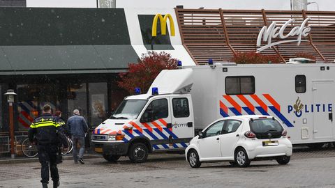 Polizisten ermittelt am Tatort, an dem zwei Männer nach Schüssen in einem Schnellrestaurant ums Leben gekommen sind