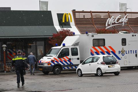 Polizisten ermittelt am Tatort, an dem zwei Männer nach Schüssen in einem Schnellrestaurant ums Leben gekommen sind