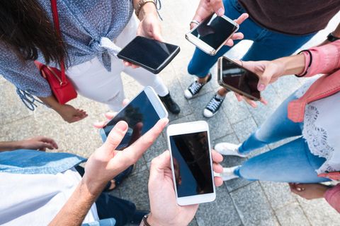 Welches Smartphone passt zu mir? Eine Gruppe von Personen steht im Kreis und hält ihre Smartphones in die Mitte.