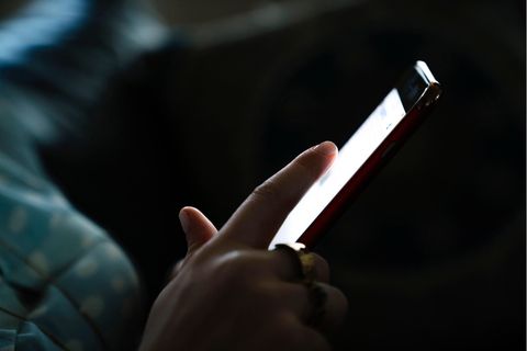 Frau schreibt SMS an einem Smartphone.