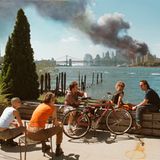 Thomas Hoepker nahm dieses Bild am 11.09.2001 auf. Gruppe junger Menschen, im Hintergrund das brennende World Trade Cent