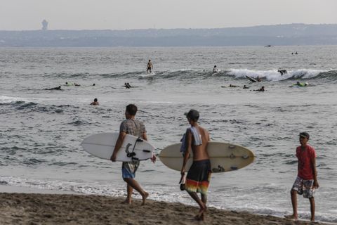 Jungen mit Surfbretter am Strand von Bali