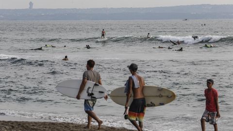 Jungen mit Surfbretter am Strand von Bali