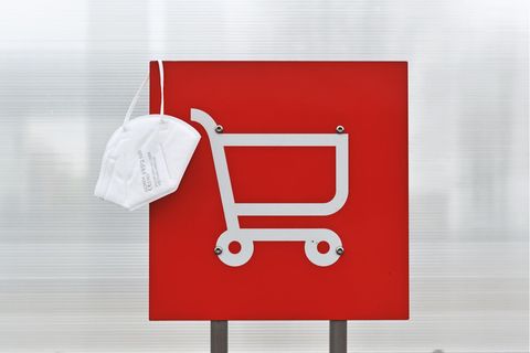 Eine FFP"-Maske hängt über einen Schild für Einkaufswagen