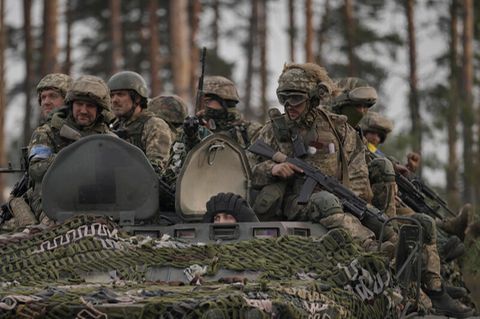 Ukrainische Soldaten sitzen auf einem Schützenpanzer