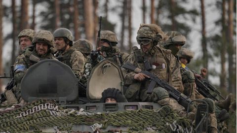 Ukrainische Soldaten sitzen auf einem Schützenpanzer