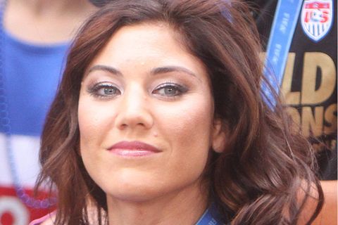 Die ehemalige US-amerikanische Torhüterin Hope Solo sitzt auf einer Tribüne und lächelt