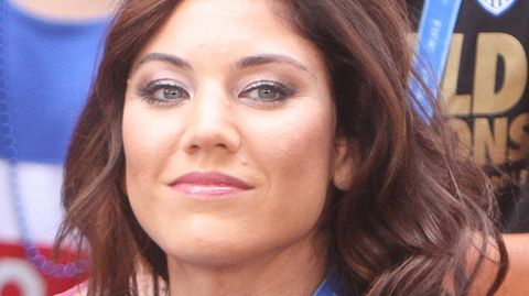 Die ehemalige US-amerikanische Torhüterin Hope Solo sitzt auf einer Tribüne und lächelt
