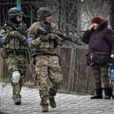 Eine Frau sieht ukrainische Soldaten vorbeigehen