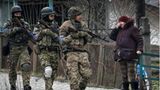 Eine Frau sieht ukrainische Soldaten vorbeigehen