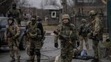 Ukrainische Soldaten stehen inmitten von Butscha und untersuchen die Leichen von Zivilisten auf Sprengfallen